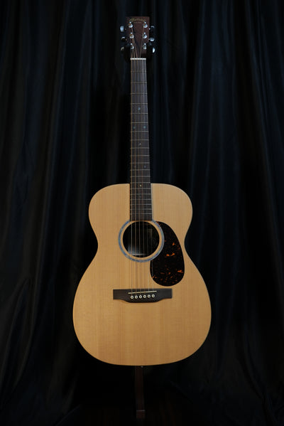 Angled full-body view of Martin 00-X2E highlighting the 00 shape and Brazilian rosewood HPL back and sides