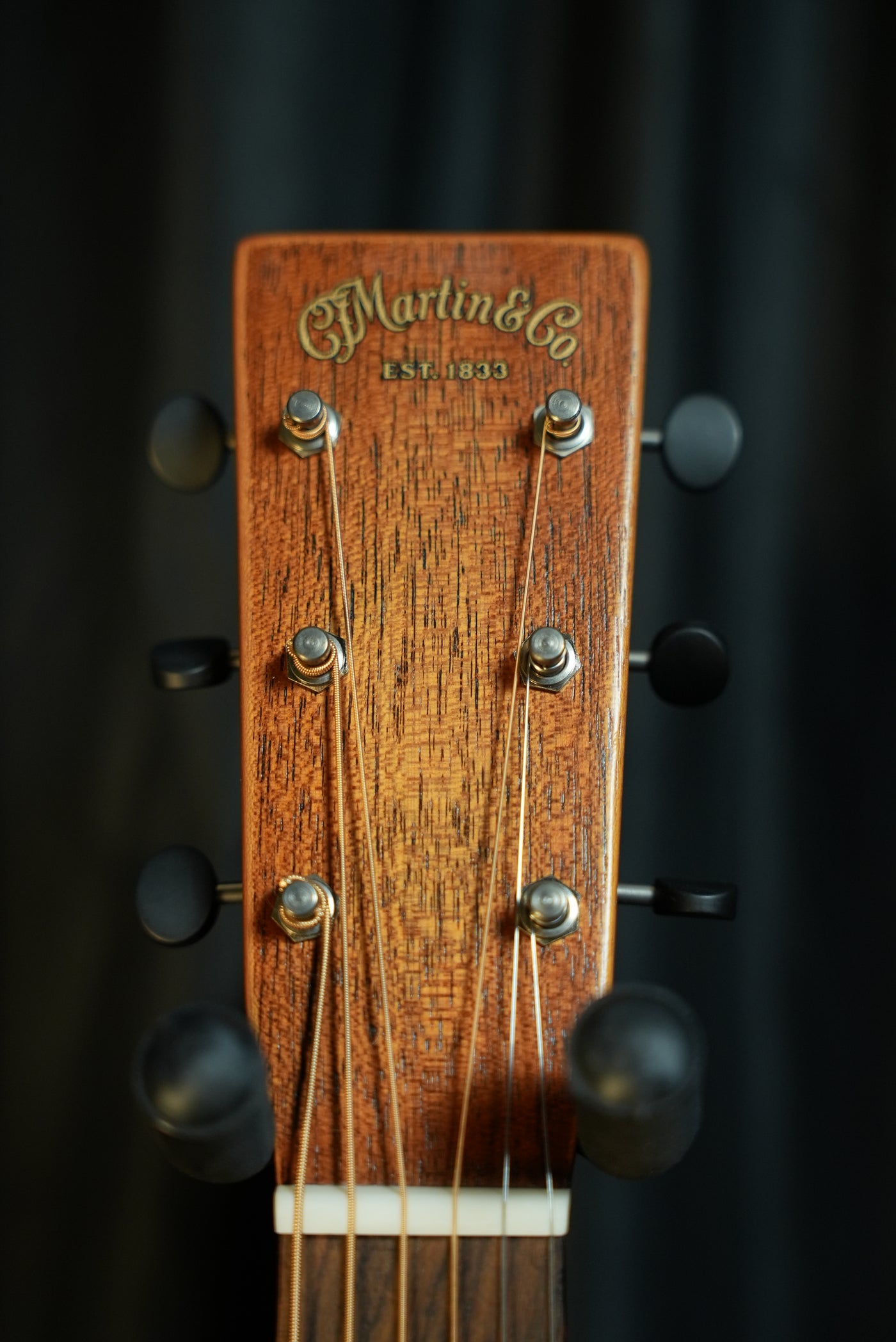 Close-up of Martin D-15M StreetMaster headstock with Martin decal logo and aged nickel open-gear tuners with butterbean knobs