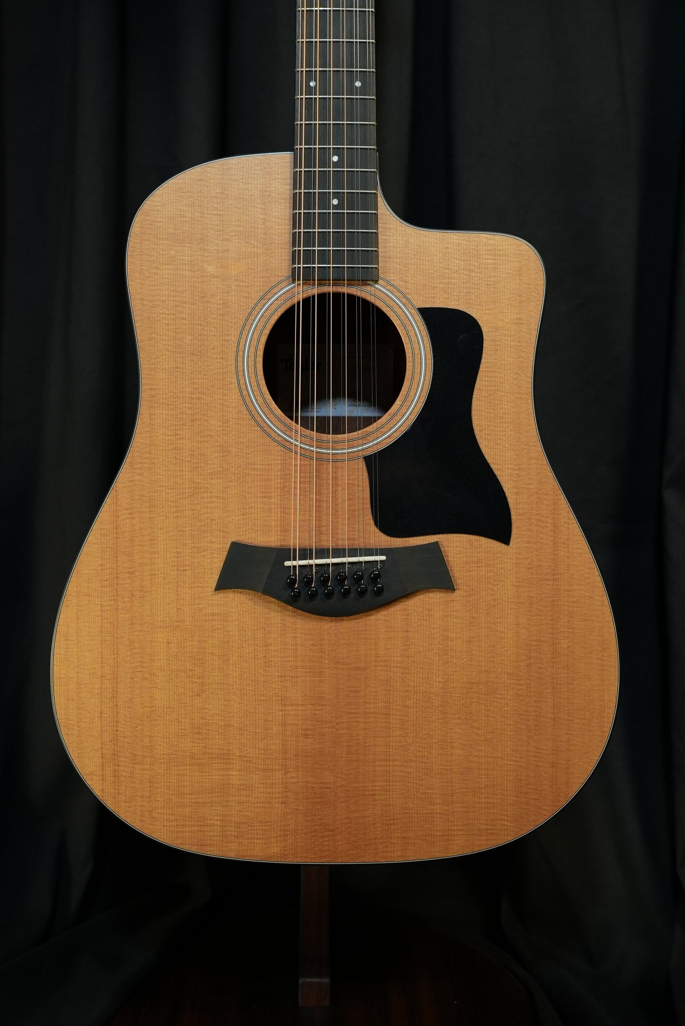 Front full-body view of the Taylor 150ce 12-string acoustic-electric guitar in natural finish, featuring a solid spruce top and layered sapele back and sides for rich tone.