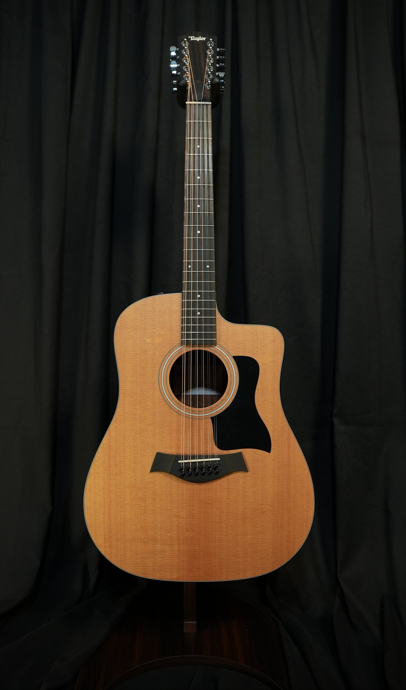 Studio-style presentation of the Taylor 150ce in natural finish under lighting, highlighting contours, wood grain, and premium feel for national ecommerce.
