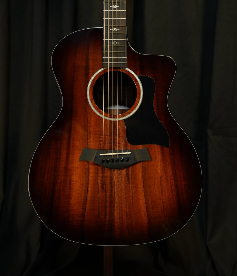 Full front view of the Taylor 224ce-K DLX showing solid koa top and Grand Auditorium body shape.