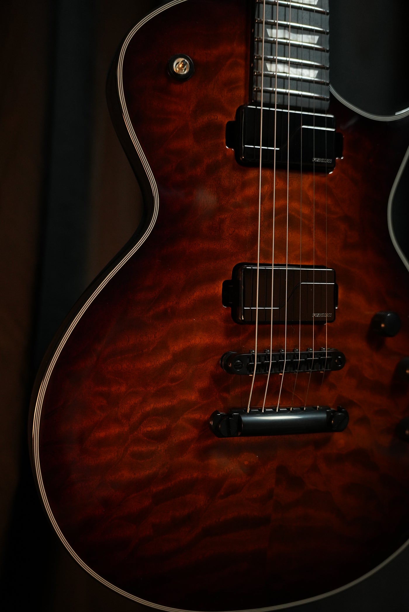 Close-up of ESP E-II Eclipse Tiger Eye Sunburst Fishman Fluence Modern Humbucker pickups and Gotoh bridge
