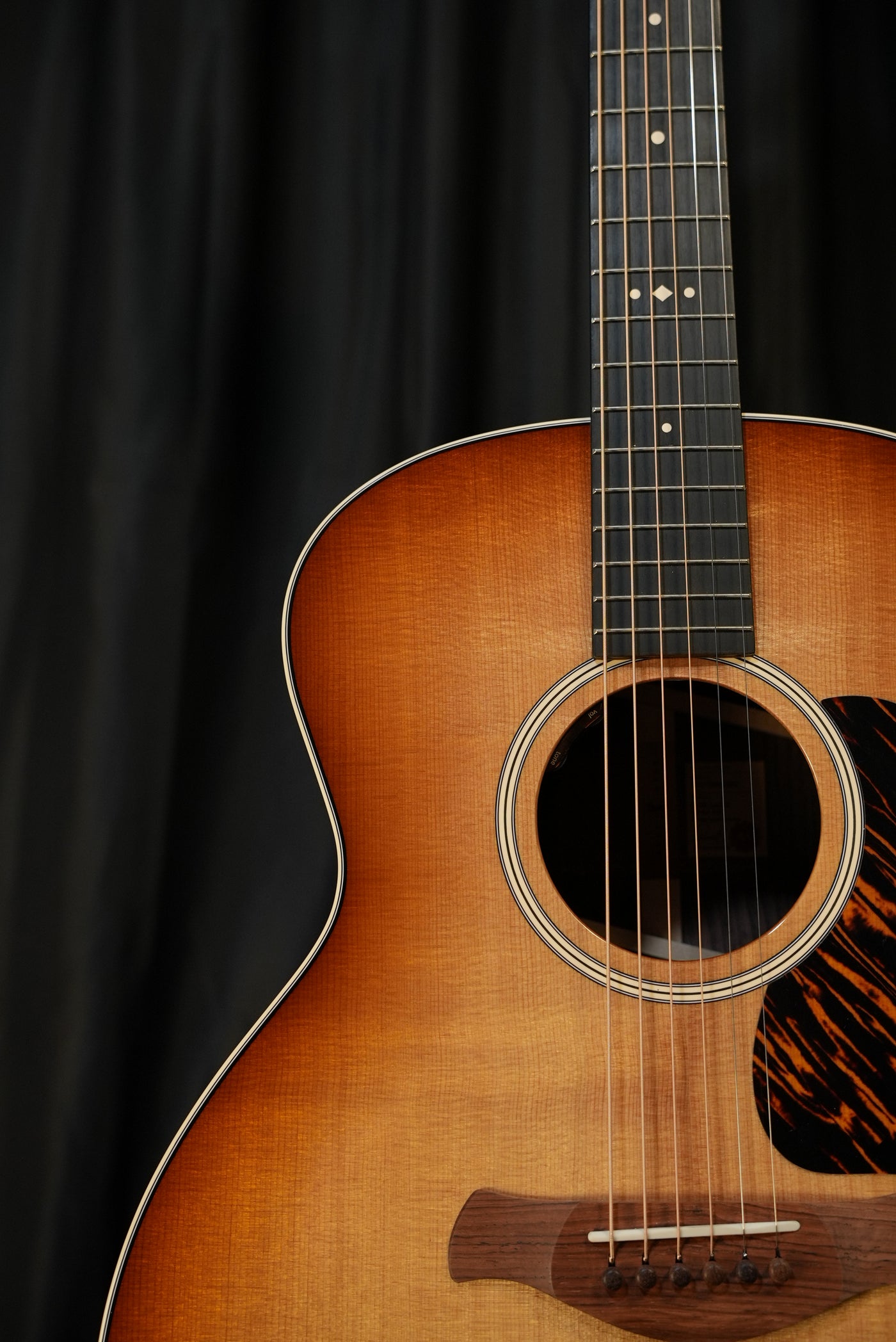 Taylor Gold Label 714e Sunburst top wood grain and Firestripe pickguard texture close-up acoustic-electric USA